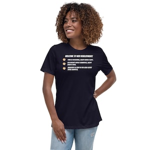 May include: A navy blue t-shirt with a white graphic that says "WELCOME TO WEB DEVELOPMENT!" and lists a few humorous rules about web development.