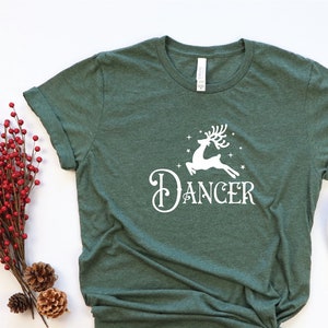 May include: A green t-shirt with a white reindeer and the text "Dancer" printed on the front.