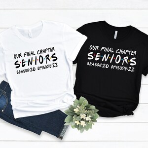 May include: Two t-shirts, one white and one black, with the text "Our Final Chapter Seniors Season:20 Episode:22" in a stylized font. The text is in black on the white shirt and in white on the black shirt.