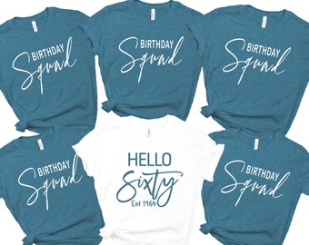 May include: Set of five teal blue t-shirts with white text. Four shirts say "Birthday Squad" and one shirt says "Hello Sixty Est 1964".
