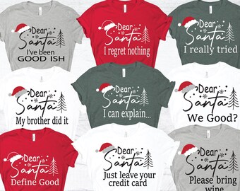 May include: A collection of nine short-sleeved t-shirts in red, white, gray, and dark green. Each shirt features a graphic with a Santa hat, a pine tree, snowflakes, and the text Dear Santa followed by phrases like I've been GOOD ISH, I regret nothing, I really tried, My brother did it, I can explain, We Good, Define Good, Just leave your credit card, and Please bring wine.