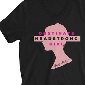 May include: Black V-neck t-shirt with a pink silhouette of a woman's head and the text "Obstinate Headstrong Girl - Jane Austen" in pink.