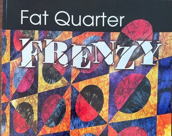 May include: Book cover with a colorful geometric pattern of red, yellow, blue, and black circles. The title is "Fat Quarter Frenzy" and the authors are Susan Purney-Mark and Daphne Greig.