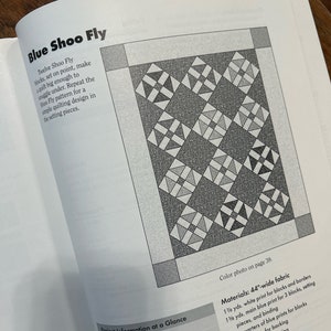 K&ouml;nnte beinhalten: Ein Quiltmuster f&uuml;r einen Quilt namens "Blue Shoo Fly". Das Muster besteht aus 12 Bl&ouml;cken, die jeweils 19 cm x 19 cm gro&szlig; sind. Der fertige Quilt misst 107 cm x 132 cm.