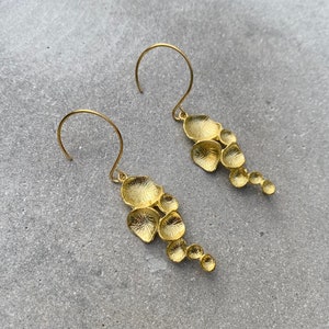 Stylish stainless steel earrings with ornate brass leaves by SaraBokwallDesign.