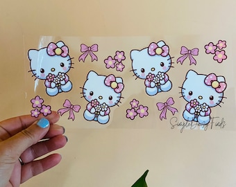 May include: Clear sheet with multiple Hello Kitty character stickers. Each character is white with a pink bow and holding flowers. Pink bows and flower clusters are also scattered across the sheet. The text "Simple Daisy Finds" is in the bottom right corner.