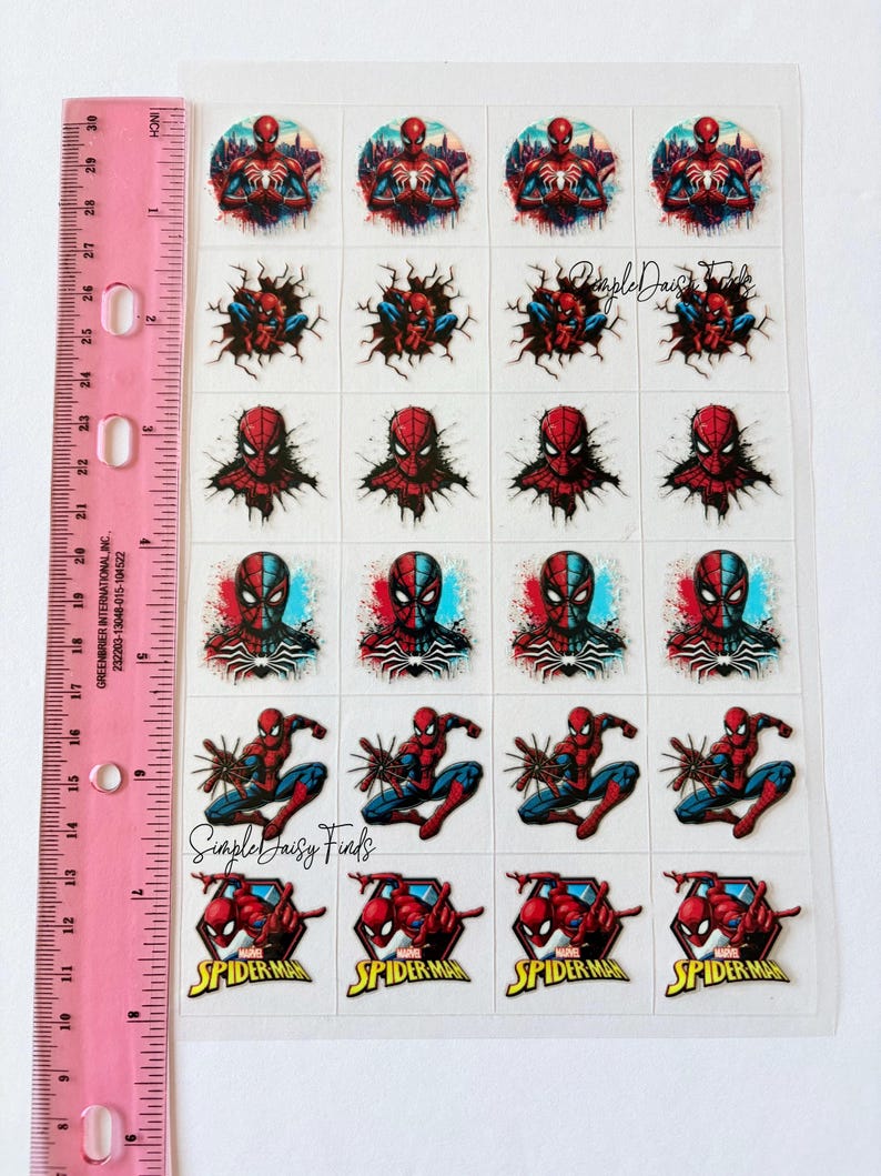 May include: A sheet of Spider-Man stickers with multiple designs. The stickers show the superhero in action and close-ups of his mask. The sheet includes the text "Spider-Man" in a red and yellow design. A pink ruler is on the left.
