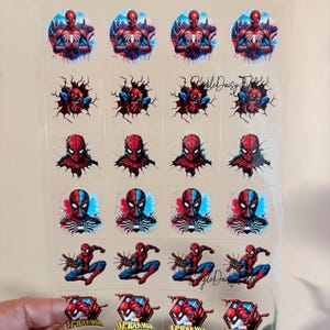 May include: A sheet of clear stickers featuring various images of Spider-Man. The stickers showcase Spider-Man in different poses and designs, with vibrant red, blue, and black colours. Some stickers include the text "Spider-Man".