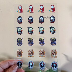 Puede incluir: Hoja transparente de pegatinas con personajes de Pesadilla antes de Navidad. Las pegatinas incluyen im&aacute;genes de Sally, Jack Skellington y otros personajes en varios dise&ntilde;os, con un tema floral y g&oacute;tico.