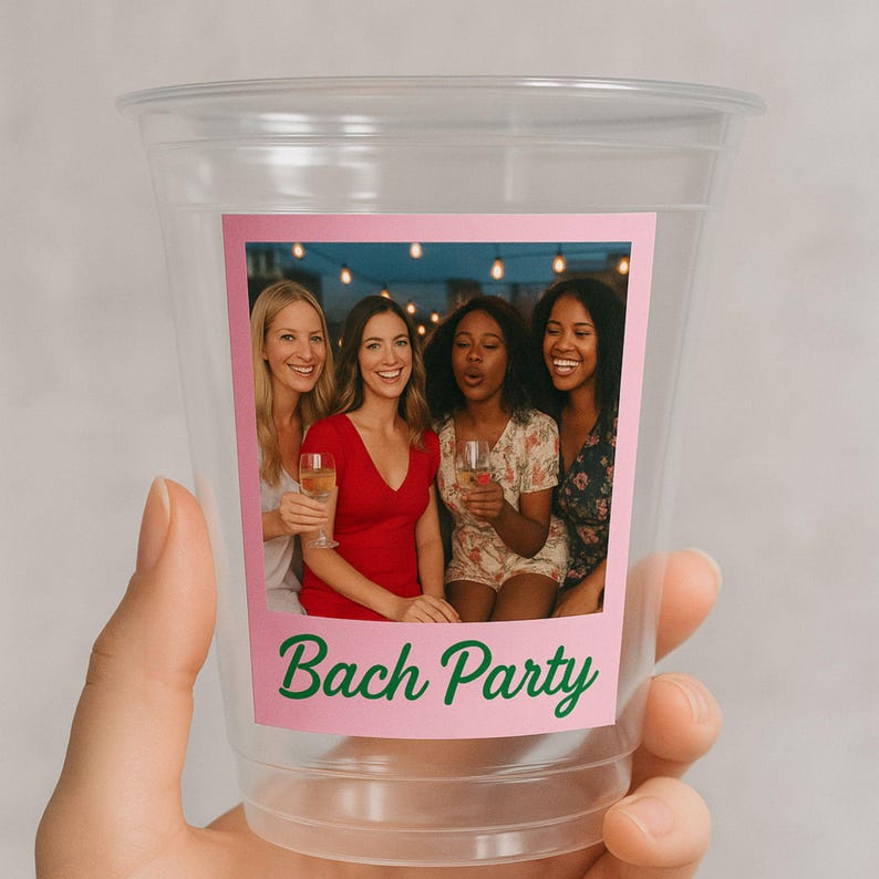 May include: Clear plastic cup with a pink rectangular label featuring a photo of four women holding drinks. The label has the text "Bach Party" in green script.