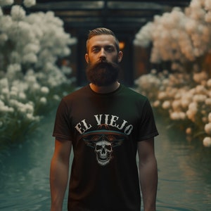 May include: A man with a beard is wearing a black t-shirt with a white skull graphic and the text "EL VIEJO" on it.