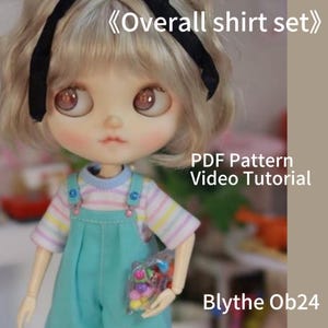 Può includere: Una bambola che indossa un completo di tuta blu chiaro e una maglietta a righe. La bambola ha i capelli biondi e tiene in mano un sacchetto di caramelle colorate. Il testo sull'immagine recita "Overall shirt set", "PDF Pattern Video Tutorial" e "Blythe Ob24".