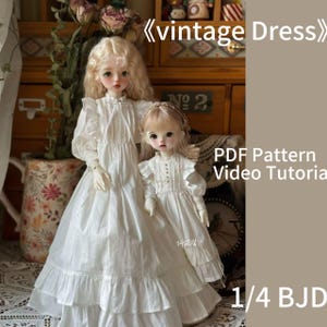 Könnte beinhalten: Zwei weiße Puppenkleider mit Rüschendetails. Die Kleider sind für 1/4 BJD-Puppen. Das Bild enthält den Text "vintage Dress", "PDF Pattern", "Video Tutorial" und "1/4 BJD".