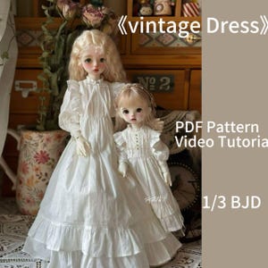 Może przedstawiać: Dwie białe sukienki dla lalek z falbankami. Sukienki są wykonane dla lalki BJD 1/3. Obraz zawiera tekst "vintage Dress", "PDF Pattern", "Video Tutorial" i "1/3 BJD".
