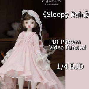 Op de afbeelding: Een roze jurk met kantversiering en een witte kanten kraag, gedragen door een pop met bruin haar en een witte kanten hoed. De tekst "Sleepy Rain" staat in grote letters boven de pop. De tekst "PDF Pattern Video Tutorial 1/4 BJD" staat onder de pop.