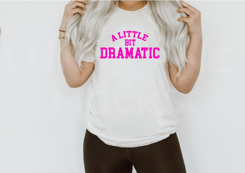 May include: White t-shirt with pink text that reads "A little bit dramatic".