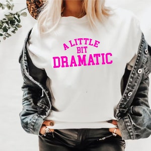 May include: White sweatshirt with a pink graphic that says "A Little Bit Dramatic".