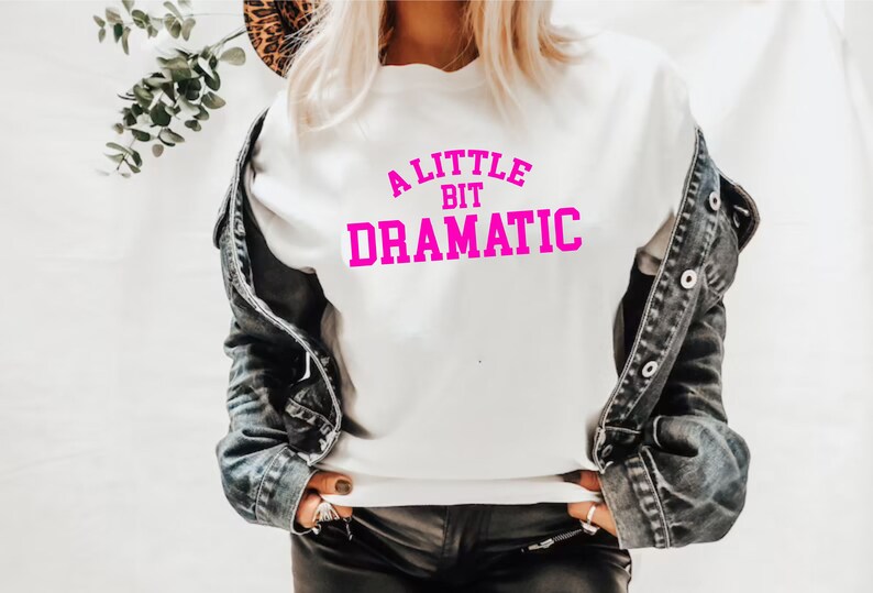 May include: White sweatshirt with a pink graphic that says "A Little Bit Dramatic".