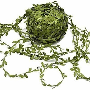 Op de afbeelding: Een rol groene kunstmatige bladerenkrans. De krans is gemaakt van stoffen bladeren en is perfect om elke ruimte een vleugje groen te geven.