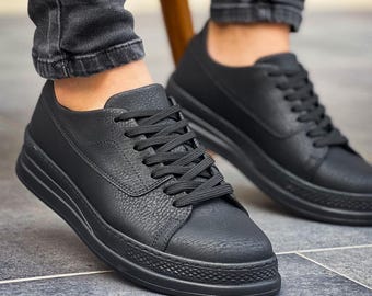 May include: A pair of black leather low-top sneakers with a textured finish and black laces.