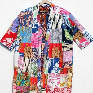 May include: A patchwork kimono-style jacket with a vibrant mix of floral, tiger, and geometric patterns in red, blue, pink, and green. The jacket features a relaxed fit with short sleeves and a collarless design, perfect for layering.