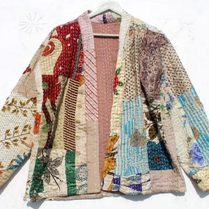 May include: A patchwork quilted jacket with a variety of colors and patterns, including floral, geometric, and striped designs. The jacket has a long, open front and long sleeves.
