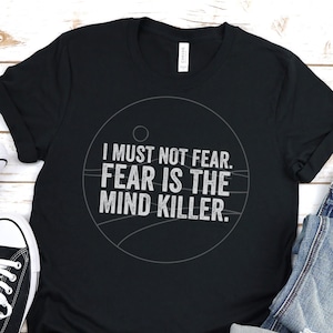 May include: Black t-shirt with a white circle graphic and the text "I must not fear. Fear is the mind killer."