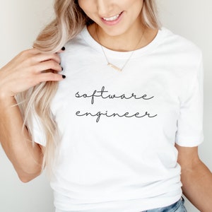 May include: White t-shirt with the text "software engineer" written in black cursive script.