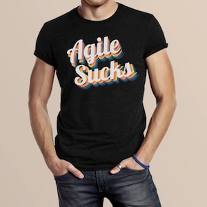 May include: A black t-shirt with a retro-style graphic that says "Agile Sucks" in white letters with rainbow-colored outlines.