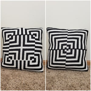 Puede incluir: Dos fundas de cojín de crochet en blanco y negro con un patrón geométrico. Los cojines son cuadrados y tienen un patrón repetitivo de cuadrados blancos y negros.