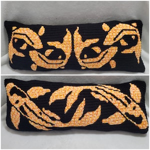 Peut inclure: Deux housses de coussin en crochet noir et orange avec un motif de deux poissons koï. Les coussins sont faits avec un fil texturé et ont un design détaillé.