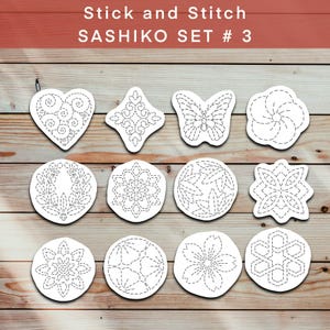 May include: A collection of white fabric patches with intricate black stitched designs. The patches feature various shapes, including a heart, butterfly, and floral patterns. The text "Stick and Stitch SASHIKO SET # 3" is displayed at the top.