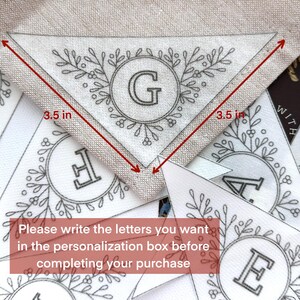 Peut inclure: Un ensemble de fanions en tissu blanc avec des contours noirs et des motifs floraux. Chaque fanion pr&eacute;sente une lettre dans un cercle. Les fanions mesurent 8,9 cm de large. Le texte sur l'image indique : "Veuillez &eacute;crire les lettres que vous souhaitez dans la bo&icirc;te de personnalisation avant de finaliser votre achat."