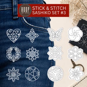 Pode incluir: Um Stick & Stitch Sashiko Set #3 com padrões de bordado adesivos brancos em tecido jeans azul escuro. Os designs incluem um coração, uma borboleta, flores e formas geométricas. O conjunto é exibido com uma pequena tesoura.