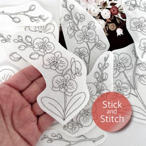Peut inclure: Des patchs en tissu blanc avec des dessins au trait noirs de fleurs et de tiges d'orchidées. Les patchs sont de formes et de tailles variées. Un cercle rouge avec les mots "Stick and Stitch" est visible.