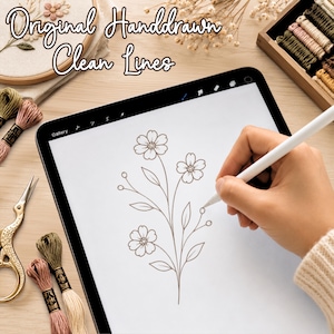 May include: A digital tablet displaying a hand-drawn floral illustration with clean lines, being drawn with a white stylus. The text Original Handdrawn Clean Lines is visible at the top. Embroidery floss, scissors, and a hoop are nearby.