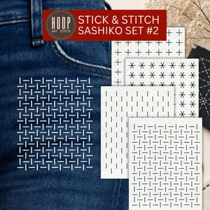 May include: A Stick & Stitch Sashiko Set #2 featuring multiple white adhesive embroidery stabilizer sheets with black geometric patterns, including crosses, stars, and dashed lines, applied to dark blue denim fabric for needlework.