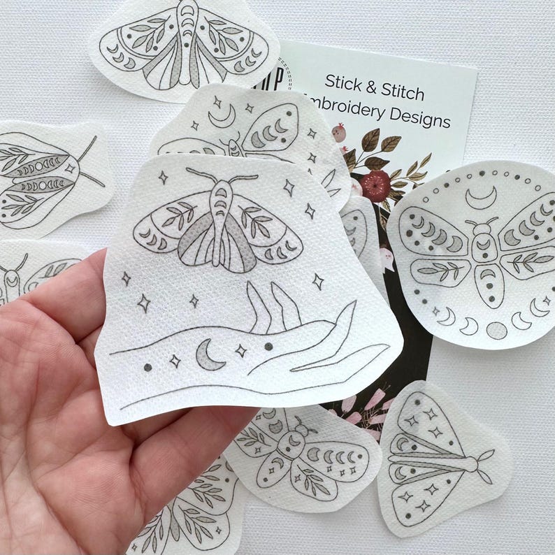 May include: A set of 10 iron-on embroidery designs featuring moths, moons, and stars. The designs are printed on white fabric and are perfect for adding a touch of whimsy to your projects.