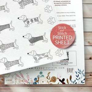 May include: A white printable sheet with a repeating pattern of dachshund dogs wearing sweaters. The sheet is labeled "Stick and Stitch Printed Sheet".