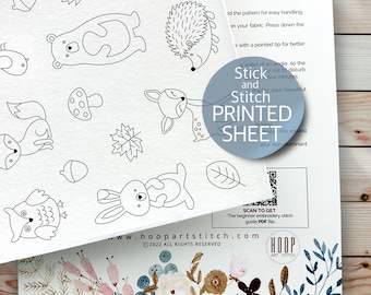 May include: A black and white printable embroidery pattern sheet featuring woodland animals such as a fox, owl, bear, deer, hedgehog, rabbit, and mushrooms. The sheet includes the text "Stick and Stitch Printed Sheet" and a QR code to scan for a beginner embroidery stitch guide PDF file.