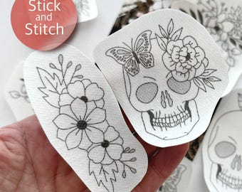 May include: Two white fabric patches with black line drawings. One patch features a skull with flowers and a butterfly. The other patch features a floral design. The text "Stick and Stitch" is visible in the background.