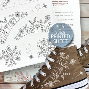 May include: Brown high-top trainers with white laces and a floral design. A printed sheet with floral and bee patterns is visible. The text "Stick and Stitch PRINTED SHEET" is also visible.