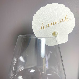 Champagne-plaatskaarten met geperste schelpdetails en parelaccenten - schelp-huwelijksdrankje - glazen naamkaartje met tafelnummer