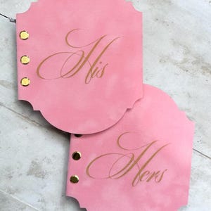 May include: A handmade wooden sign with the text "Welcome to our home" in a handwritten style. The sign is painted white with a dark stained frame. A small green plant is placed on the sign.