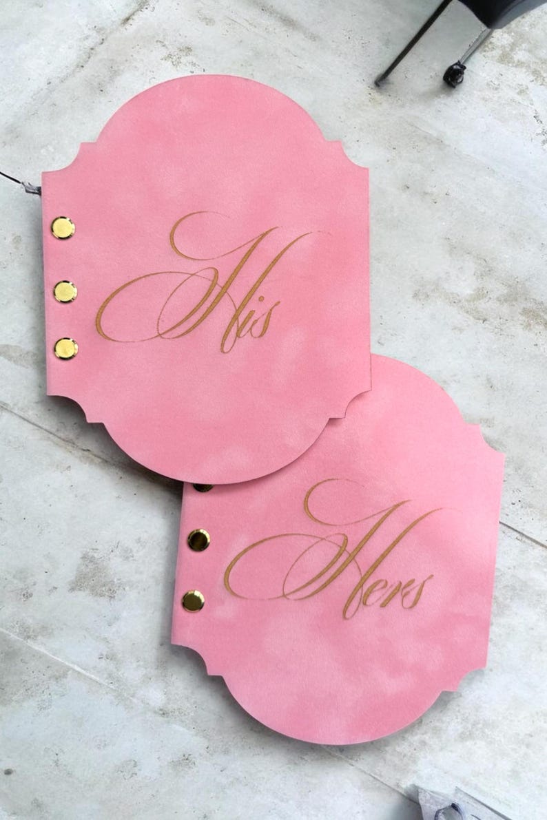 May include: A handmade wooden sign with the text "Welcome to our home" in a handwritten style. The sign is painted white with a dark stained frame. A small green plant is placed on the sign.