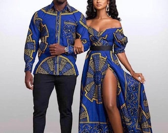 Op de afbeelding: Een stel draagt bijpassende blauwe en gouden shirts met patronen. De vrouw draagt een lange, off-shoulder jurk met een hoge split. Ze draagt ook een bloemenkrans.