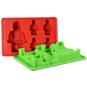 May include: A red and green silicone mould for making chocolate or candy in the shape of Lego minifigures. The mould has six cavities, including one large figure and five smaller figures.