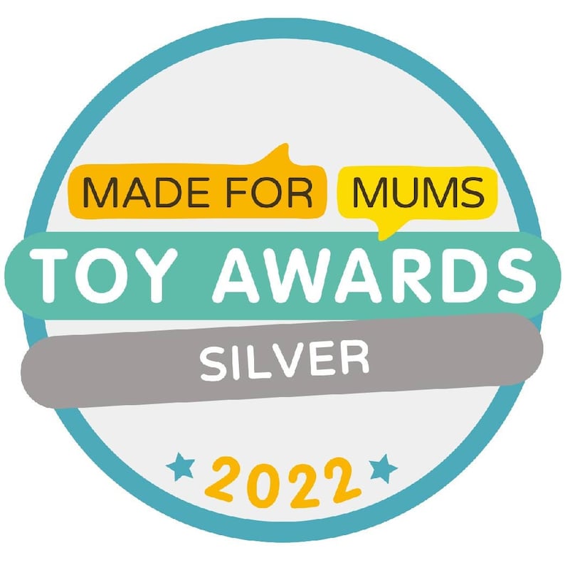Op de afbeelding: Een blauwe en witte cirkel met de tekst "MADE FOR MUMS TOY AWARDS SILVER 2022" in geel en wit.