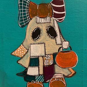 May include: A painting on a teal background featuring a ghost character made of various patchwork fabric squares in shades of cream, brown, and dark purple. The ghost wears a large bow, carries an orange pumpkin bucket, and has brown shoes.