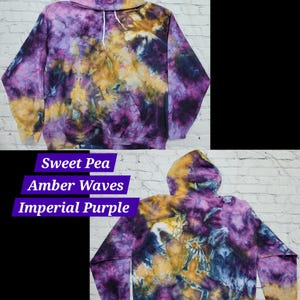 May include: A tie-dye hoodie in shades of purple, yellow, and blue. The hoodie has a drawstring hood and a kangaroo pocket. The text "Sweet Pea, Amber Waves, Imperial Purple" is written below the image.